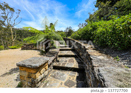 Scenic view across Everglades Gardens in the Blue Mountains of New South Wales, Australia, showing landscaped gardens, pathways and surrounding mountain scenery. 137727700