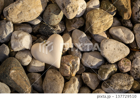 A figurine of a stone heart lies among the stones 137729510