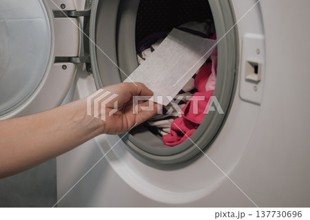 innovative color trap sheet close up in washing machine drum with pile of varied clothes innovative color trap sheet close up in washing machine drum with pile of varied clothes 137730696