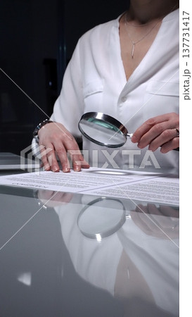 Woman analyzing contract text with magnifying glass, scrutinizing fine print for legal details and agreement review. Audit, business and overworking concepts Woman analyzing contract text with magnifying glass, scrutinizing fine print for legal details and agreement review. Audit, business and overworking concepts 137731417