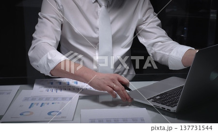 Financial professional analyzing business data on laptop, reviewing charts and reports in a modern office. Audit and taxes in business Financial professional analyzing business data on laptop, reviewing charts and reports in a modern office. Audit and taxes in business 137731544
