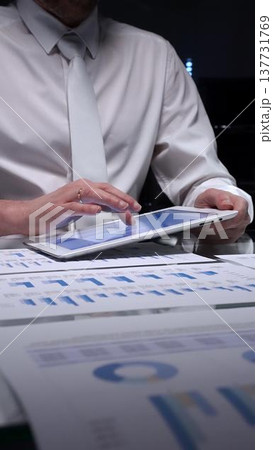 Businessman analyzing business data with tablet pc, scrutinizing financial charts for auditing and research. Audit in business and overworking concepts Businessman analyzing business data with tablet pc, scrutinizing financial charts for auditing and research. Audit in business and overworking concepts 137731769