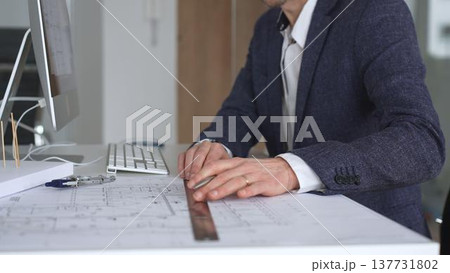 Architect hand drawing on building blueprints, architectural model and computer on desk,. Modern architecture and construction concept 137731802