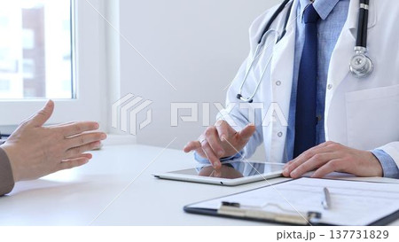 Doctor man showing information on tablet to patient woman during medical visit, explaining diagnosis and treatment options, providing medical consultation using modern technology. Medicine concept Doctor man showing information on tablet to patient woman during medical visit, explaining diagnosis and treatment options, providing medical consultation using modern technology. Medicine concept 137731829