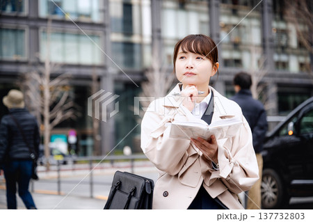 手帳を見る若いビジネスウーマン 137732803