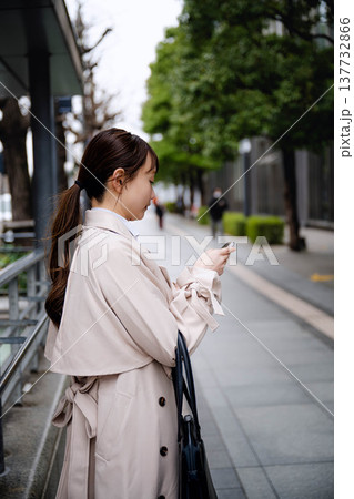 オフィス街で通話をする若いビジネスウーマン オフィス街で通話をする若いビジネスウーマン 137732866