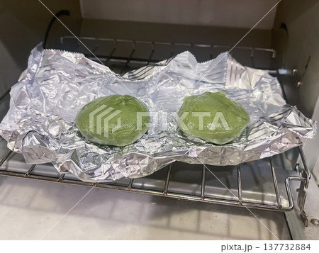 トースターで焼いた和菓子のよもぎ餅。あんこを蓬を練り込んだ餅で包んだ日本のお菓子。 トースターで焼いた和菓子のよもぎ餅。あんこを蓬を練り込んだ餅で包んだ日本のお菓子。 137732884