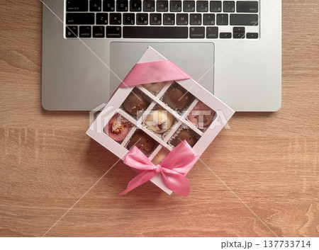 Delicious, sweet handmade chocolates made of white and milk chocolate with whole nuts in a gift box on a light background. High quality photo 137733714