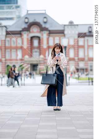 屋外でスマホを操作するビジネスウーマン 137734035