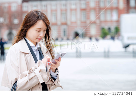 屋外でスマホを操作するビジネスウーマン 屋外でスマホを操作するビジネスウーマン 137734041