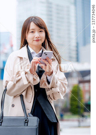 屋外でスマホを操作するビジネスウーマン 137734046