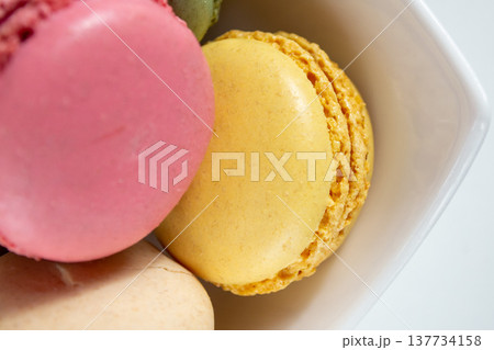 small multi-colored macaroons in a white plate on a white background small multi-colored macaroons in a white plate on a white background 137734158
