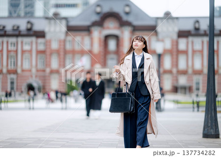 スーツ姿で東京駅前を歩くビジネスウーマン スーツ姿で東京駅前を歩くビジネスウーマン 137734282