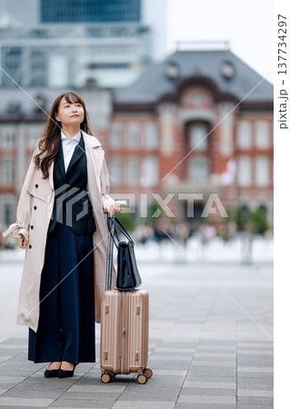 スーツ姿で東京駅前を歩くビジネスウーマン 137734297