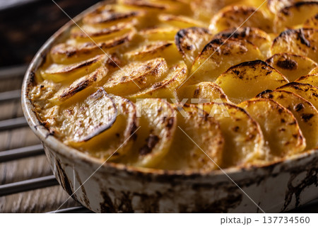 Golden-brown gratin potatoes, neatly arranged in a white ceramic bowl. However, in Slovakia, this dish is known primarily at home as French potatoes. 137734560