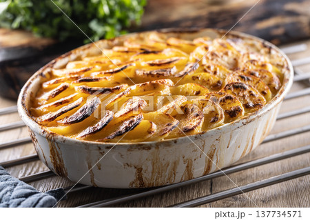 Golden-brown gratin potatoes, neatly arranged in a white ceramic bowl. However, in Slovakia, this dish is known primarily at home as French potatoes. Golden-brown gratin potatoes, neatly arranged in a white ceramic bowl. However, in Slovakia, this dish is known primarily at home as French potatoes. 137734571