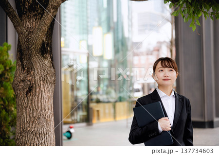 ノートパソコンを胸に抱える若い女性 ノートパソコンを胸に抱える若い女性 137734603