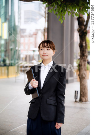 ノートパソコンを胸に抱える若い女性 ノートパソコンを胸に抱える若い女性 137734604