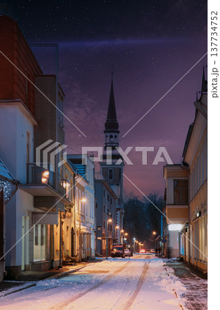 Spire of St. Elizabeth's Church from a snowy illuminated street in Parnu Old Town at winter night Spire of St. Elizabeth's Church from a snowy illuminated street in Parnu Old Town at winter night 137734752