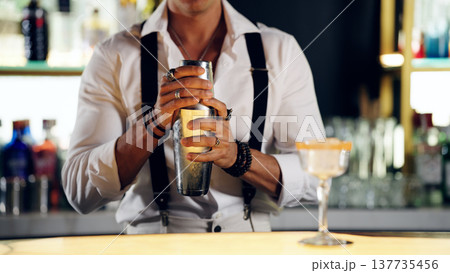 Bartender shaking cocktail creating a refreshing drink at bar Bartender shaking cocktail creating a refreshing drink at bar 137735456