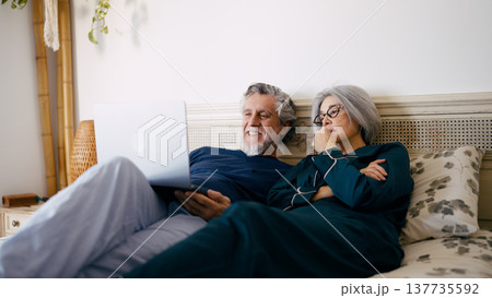 Senior couple relaxing in bed watching laptop 137735592