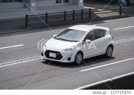 道路を走行中のハイブリッドコンパクトカー　 137735870