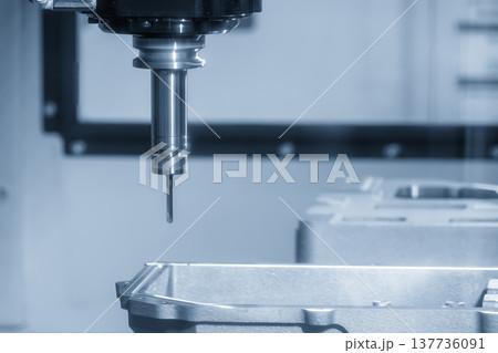 High-precision hole making process on aluminum automotive components using a CNC milling machine in a modern factory. High-precision hole making process on aluminum automotive components using a CNC milling machine in a modern factory. 137736091
