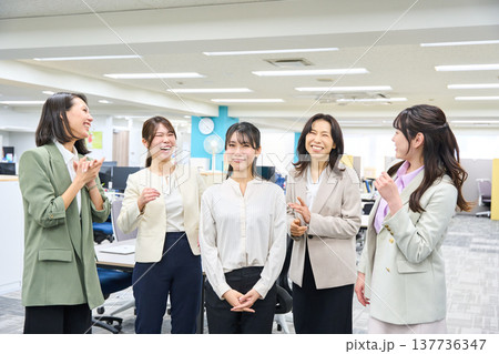 明るいオフィスで談笑しコミュニケーションをとる女子社員のグループ 137736347