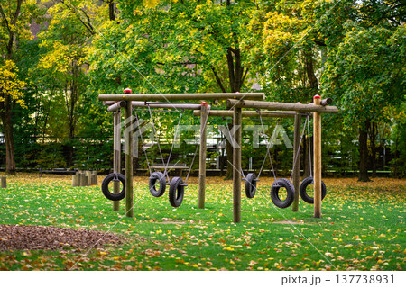 View of a swing made from car tires on a playground View of a swing made from car tires on a playground 137738931