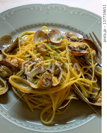 View of a round plate with Italian pasta vongole on a trattoria table in Italy View of a round plate with Italian pasta vongole on a trattoria table in Italy 137739651
