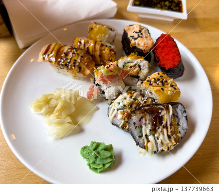 Plate with various types of Japanese sushi and sushi rolls in a restaurant Plate with various types of Japanese sushi and sushi rolls in a restaurant 137739663