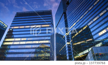 Osaka, Japan - Sep 25 2024, panoramic view from below of the reflecting glass facades of skyscrapers, lights are on on some floors, in Umeda district, at night, without people, Osaka, Japan 137739768