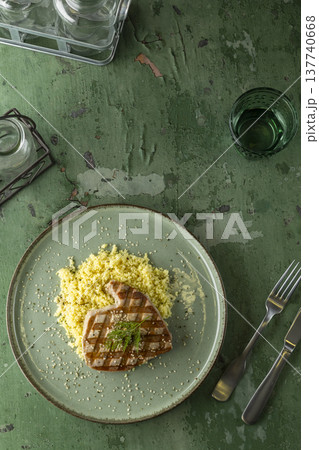 Grilled tuna steak with couscous on rustic table Grilled tuna steak with couscous on rustic table 137740668