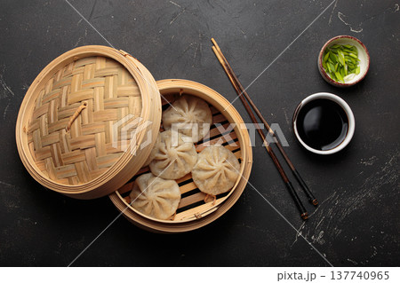 Chinese food dim sum bao dumplings bamboo steamer chopsticks black background Chinese food dim sum bao dumplings bamboo steamer chopsticks black background 137740965