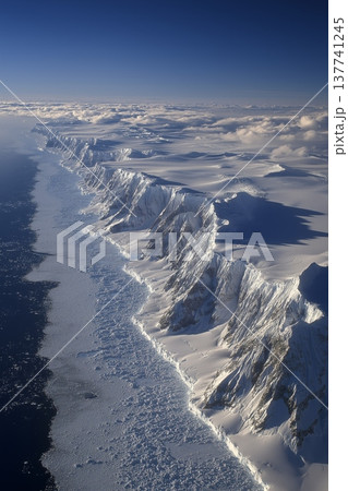 Antarctic frozen landscape showing vast ice and towering mountains. Frozen Antarctic landscape with towering, snow-covered mountains, glaciers, and sea ice 137741245