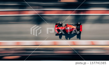 Red racing car speeding on a blurred track. Racing car creating motion blur effect on a track, viewed from above 137741385