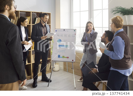 Business team training with coach at flipchart in office meeting presentation Business team training with coach at flipchart in office meeting presentation 137741434