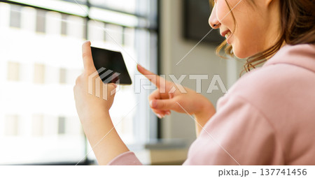 女性がスマホを横向きで操作 137741456