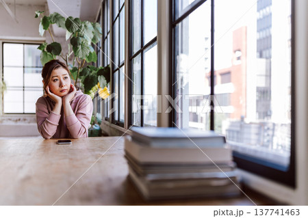 窓辺で物思いにふける女性 137741463