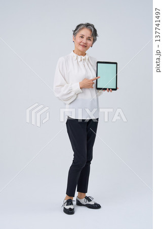 デジタルデバイスを手にするシニア女性 137741497