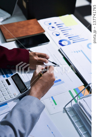 Business people analyzing monthly budget and financial report using data and chart to strategize and plan for their future business while working together in the office. Business people analyzing monthly budget and financial report using data and chart to strategize and plan for their future business while working together in the office. 137741765