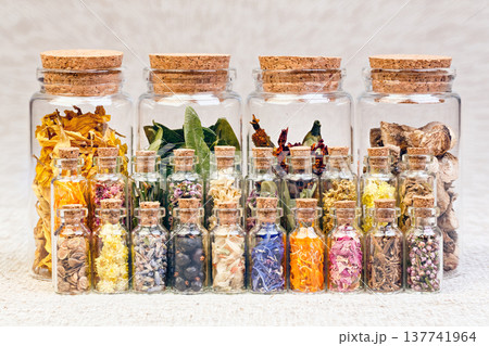Healing herbs and tinctures in bottles on sackcloth, dried flowe 137741964