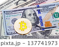 Closeup of golden yellow bitcoin on hundred dollars banknote, ma 137741973