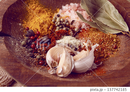 spice mix, garlic and bay leaf, on a wooden plate, close-up, food concept, no people, 137742185