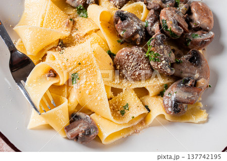 Delicious pappardelle pasta with mushrooms and cream served on a white plate 137742195
