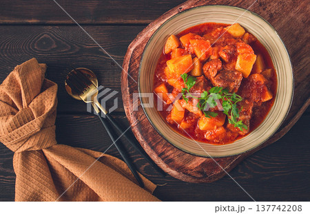 Stew with potatoes, in tomato sauce, with spices and herbs, close-up, no people, on a black background 137742208