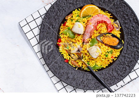 Seafood paella on a black plate, no people, 137742223