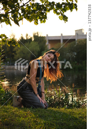 woman kneels by a lakeside, her hair flowing freely in the golden sunset, embodying strength and vulnerability. This moment captures the essence of individuality and the quiet power of authenticity. woman kneels by a lakeside, her hair flowing freely in the golden sunset, embodying strength and vulnerability. This moment captures the essence of individuality and the quiet power of authenticity. 137742838