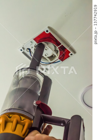 Cleaning dust from a ceiling exhaust fan ventilation system using a cordless handheld vacuum cleaner. Cleaning dust from a ceiling exhaust fan ventilation system using a cordless handheld vacuum cleaner. 137742919