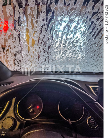 Driver's POV in an automatic car wash with foam covering the windshield. 137742928